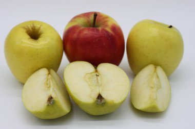 Altın ve kırmızı elmalar bir bütün ve beyaz arkaplanda çeyreklikler halinde kesilmiş.