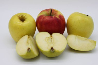 Altın ve kırmızı elmalar bir bütün ve beyaz arkaplanda çeyreklikler halinde kesilmiş.