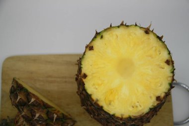 Tahta kesme tahtasında dilimlenmiş ananas meyvesi.