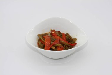 Bir kasede kırmızı ve yeşil biber, beyaz arka planda izole edilmiş.