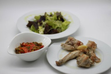 Sağlıklı salata, tavşan yahnisi ve kızarmış kırmızı ve yeşil biber menüsü.