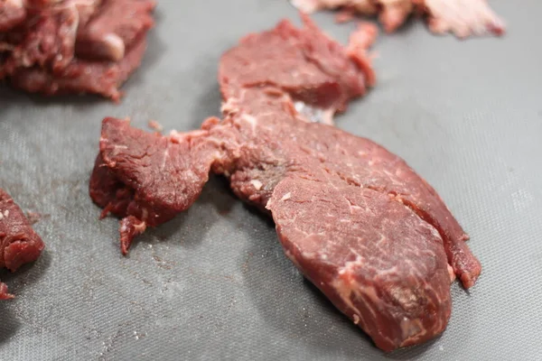 Gri bir kesme tahtasında biftek hazırlıyorum.