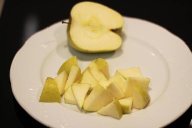 Elmalar beyaz bir tabakta kesilmiş.