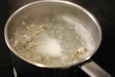 Bir tencerede bıldırcın yumurtası pişirmek.