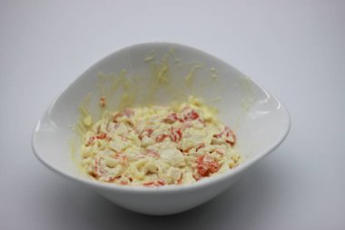 Beyaz arka planda izole edilmiş bir kasede mayonezli doğranmış yengeç.