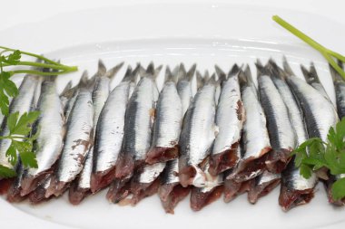 Taze yeşil maydanozla süslenmiş temiz ançüezler.