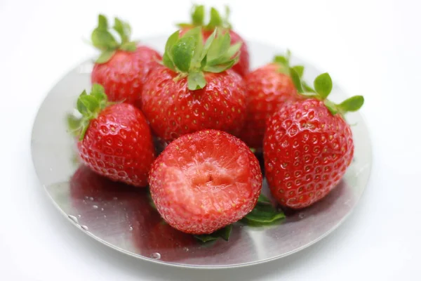 熟した赤いイチゴのプレートに白い背景に隔離された小さなイチゴ — ストック写真