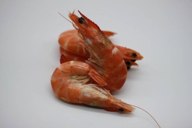 Beyaz arkaplanda pişmiş karidesler.