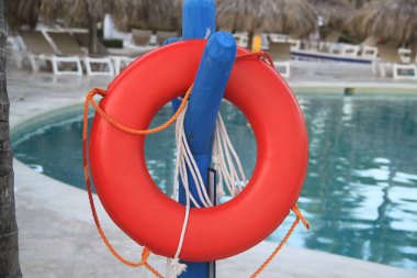 Yüzme havuzunun yanındaki kırmızı can simidi. Kurtarma kavramı