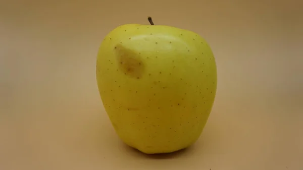 Manzanas Doradas Sobre Fondo Salmón Claro —  Fotos de Stock