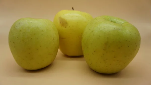 Manzanas Doradas Sobre Fondo Salmón Claro — Foto de Stock