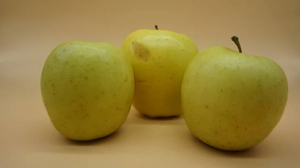 Manzanas Doradas Sobre Fondo Salmón Claro — Foto de Stock