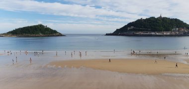 İnsanlar Donostia San Sebastian 'daki La Concha plajında geziniyorlar.