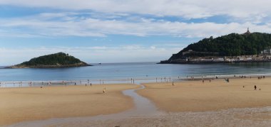 İnsanlar Donostia San Sebastian 'daki La Concha plajında geziniyorlar.