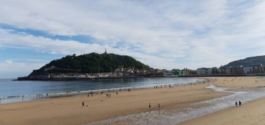 İnsanlar Donostia San Sebastian 'daki La Concha plajında geziniyorlar.