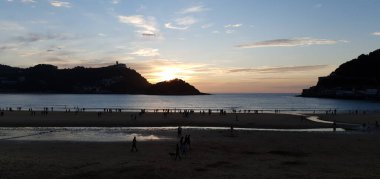 Donostia San Sebastian, Bask ülkesinde Bahia de la Concha 'da kırmızı renklerle muhteşem bir gün batımı.