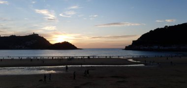 Donostia San Sebastian, Bask ülkesinde Bahia de la Concha 'da kırmızı renklerle muhteşem bir gün batımı.