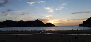 Donostia San Sebastian, Bask ülkesinde Bahia de la Concha 'da kırmızı renklerle muhteşem bir gün batımı.