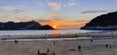 Donostia San Sebastian, Bask ülkesinde Bahia de la Concha 'da kırmızı renklerle muhteşem bir gün batımı.