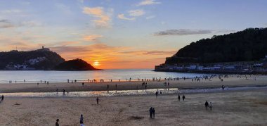 Donostia San Sebastian, Bask ülkesinde Bahia de la Concha 'da kırmızı renklerle muhteşem bir gün batımı.