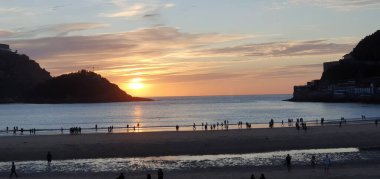 Donostia San Sebastian, Bask ülkesinde Bahia de la Concha 'da kırmızı renklerle muhteşem bir gün batımı.