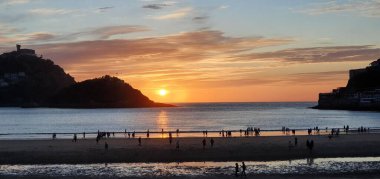 Donostia San Sebastian, Bask ülkesinde Bahia de la Concha 'da kırmızı renklerle muhteşem bir gün batımı.