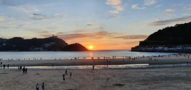 Donostia San Sebastian, Bask ülkesinde Bahia de la Concha 'da kırmızı renklerle muhteşem bir gün batımı.