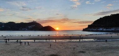 Donostia San Sebastian, Bask ülkesinde Bahia de la Concha 'da kırmızı renklerle muhteşem bir gün batımı.