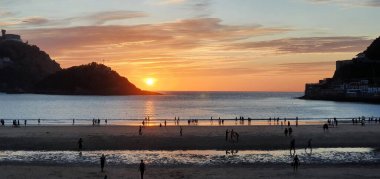 Donostia San Sebastian, Bask ülkesinde Bahia de la Concha 'da kırmızı renklerle muhteşem bir gün batımı.