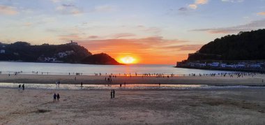 Donostia San Sebastian, Bask ülkesinde Bahia de la Concha 'da kırmızı renklerle muhteşem bir gün batımı.