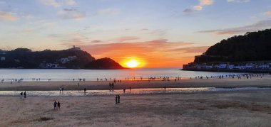 Donostia San Sebastian, Bask ülkesinde Bahia de la Concha 'da kırmızı renklerle muhteşem bir gün batımı.