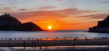 Donostia San Sebastian, Bask ülkesinde Bahia de la Concha 'da kırmızı renklerle muhteşem bir gün batımı.