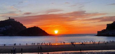 Donostia San Sebastian, Bask ülkesinde Bahia de la Concha 'da kırmızı renklerle muhteşem bir gün batımı.