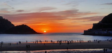 Donostia San Sebastian, Bask ülkesinde Bahia de la Concha 'da kırmızı renklerle muhteşem bir gün batımı.