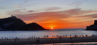 Donostia San Sebastian, Bask ülkesinde Bahia de la Concha 'da kırmızı renklerle muhteşem bir gün batımı.