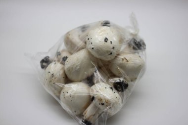 Beyaz arka planda plastik poşette mantarlar