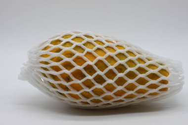 Beyaz koruyucu ağlı sarı papaya.