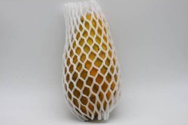 Beyaz koruyucu ağlı sarı papaya.
