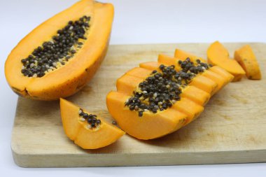 Tahta kesme tahtasında dilimlenmiş papaya.