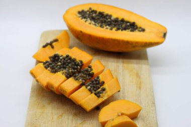 Tahta kesme tahtasında dilimlenmiş papaya.