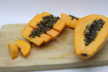 Tahta kesme tahtasında dilimlenmiş papaya.