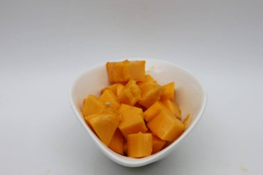 Beyaz arka planda izole edilmiş bir kase dolusu olgun papaya.