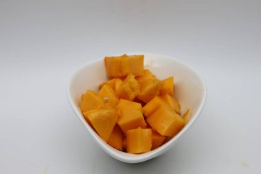 Beyaz arka planda izole edilmiş bir kase dolusu olgun papaya.