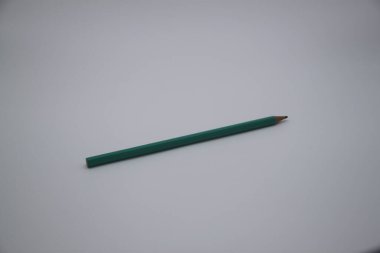 a closeup shot of a pencil placed in an old wooden table with a white background