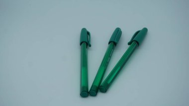 beyaz arkaplanda yeşil plastik kalemler
