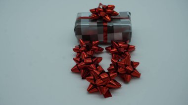 Gri kareli kağıt ve kırmızı fiyonklu hediye