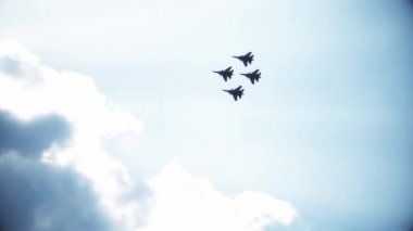 Mavi gökyüzünde dört savaş uçağı. Genel bir plan. Aerobatik figürler. Hava gösterisi. 60fps