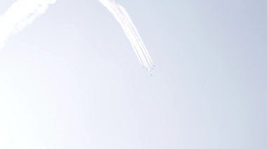 Five fighter jets in the blue sky. White color. A general plan. Aerobatic figures. Airshow. 14 seconds