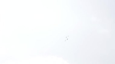Mavi gökyüzünde dört savaş uçağı. Genel bir plan. Aerobatik figürler. Hava gösterisi. 10 saniye.