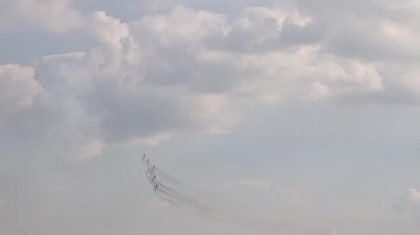 Six fighter jets in the blue sky. A general plan. Aerobatic figures. Airshow. 15 seconds